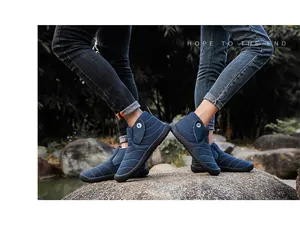 Lifestyle view of waterproof blue plush-lined winter snow boots for couples on a rock