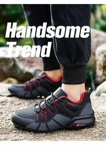Close-up of black men's outdoor hiking shoes featuring red accents and a textured sole