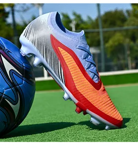 Detailed side view of light blue seamless fly-knit soccer cleats on artificial turf