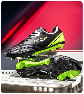 Professional black and neon green soccer cleats with long studs showing the sole detail