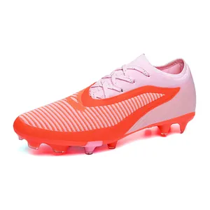 Professional pink and orange firm ground soccer cleats with breathable textured upper