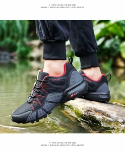 Detailed action shot of black men's breathable outdoor hiking shoes stepping into water