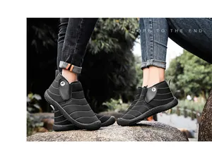 Detailed close-up of black quilted snow boots for couples worn in outdoor winter setting
