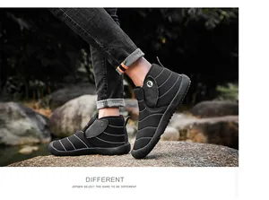 Warm black quilted winter snow boots for outdoor trekking shown in a natural rocky landscape