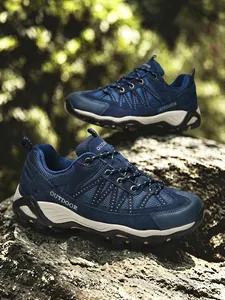 Dettaglio di scarpe da trekking blu con rete resistente e scritta Outdoor laterale.