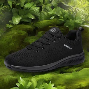 Breathable black fly-knit men's sneakers shown in a natural outdoor moss forest setting