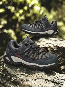 Dettaglio di scarpe da trekking grigie su una roccia con sfondo di foresta naturale