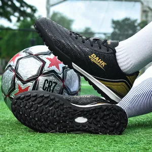Durable black turf soccer shoes for juniors and adults with rubber studs and gold details.
