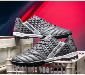Professional grey turf soccer shoes with ZUSHUNDA branding for outdoor training.