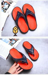 Detail view of men's beach flip-flops in navy blue and orange with anti-slip texture