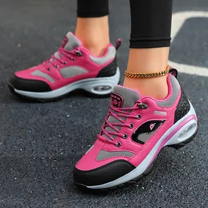 Close-up of pink and black women's hiking shoes with visible air cushion sole on track