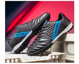 Close-up of black soccer training shoes with blue accents on textured synthetic leather