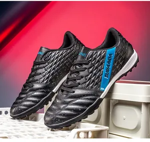 Detailed shot of black outdoor soccer shoes with blue ZUSHUNDA logo and TF studs