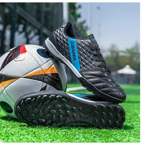 Detailed view of black and blue TF soccer shoes featuring textured upper and turf cleats