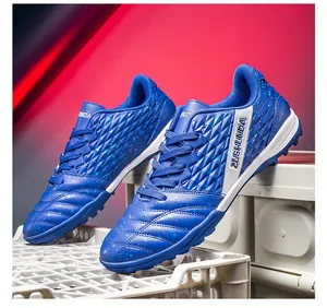 Detailed side view of blue turf soccer shoes featuring textured patterns and ZUSHUNDA logo.