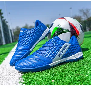 Close-up of blue textured turf soccer shoes on a grass field with a soccer ball