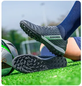 Macro view of durable grey low-top turf soccer shoes with studded soles for training