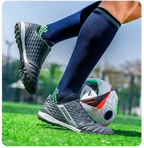 Grey TF turf soccer shoes with diamond texture pattern on green artificial grass
