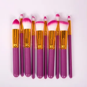 Détail d'un ensemble de 10 pinceaux de maquillage avec manches violets et poils roses.
