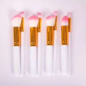 Détail d'un ensemble de pinceaux de maquillage avec poils synthétiques roses et blancs.