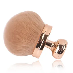 Large rose gold mushroom head makeup brush with soft light brown bristles on white background