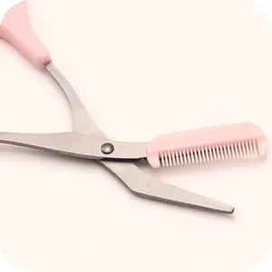 Gros plan de ciseaux à sourcils roses avec peigne intégré pour une mise en forme.