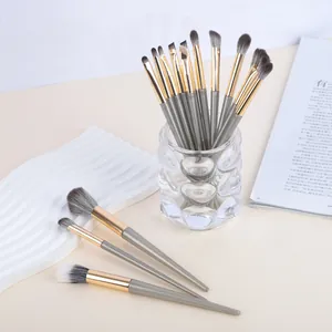 Vue détaillée d'un ensemble de pinceaux à paupières gris et or dans un verre