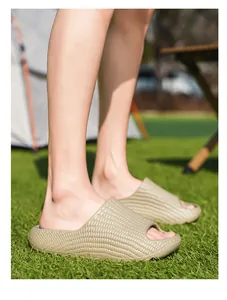 Comfortable khaki textured slide sandals worn on grass in an outdoor camping scene.
