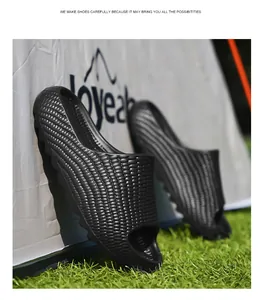 Macro view of black textured slide sandals with woven pattern on green grass background