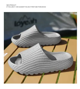 Detailed view of grey textured thick sole beach slides displayed on an outdoor table