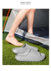 Grey textured thick-sole slides for outdoor camping and beach wear on green grass