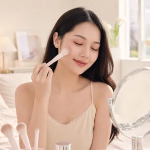 Asian model using a soft pink blush brush from a 13-piece professional makeup set