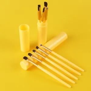 5-piece yellow makeup brush set with matching portable storage tube on yellow background.