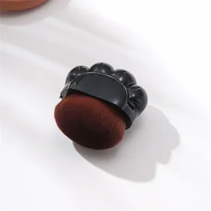 Niedlicher Make-up-Pinsel in Katzenpfotenform mit weichen braunen Synthetikborsten.