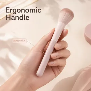 Detailed close-up showing the matte finish and ergonomic handle of a pink makeup brush