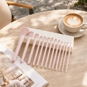Detailed close-up showing 13-piece pink professional makeup brush set on a stylish wooden table
