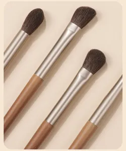 Detail of high-quality eye makeup brushes with wooden handles and soft brown bristles.