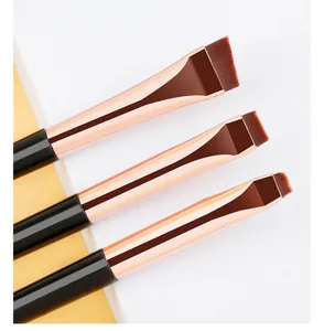 Close-up of three angled eyeliner brushes with synthetic fibers and rose gold ferrules