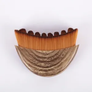Detalle de brocha facial para drenaje linfático con cerdas densas y mango efecto madera.