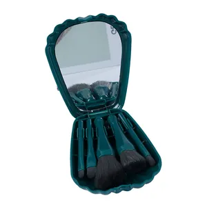 Gedetailleerd overzicht van de donkergroene schelpvormige make-up borstelset met spiegel