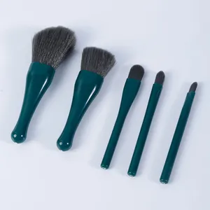 Set van vijf donkergroene make-up borstels met synthetische haren op witte achtergrond
