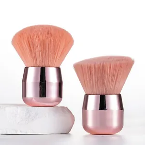 Close-up macro view of professional pink mushroom head powder brushes with rose gold metal handles
