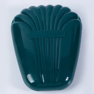 Detailweergave van de gesloten donkergroene make-up borstel opbergcase in schelpvorm met glans.