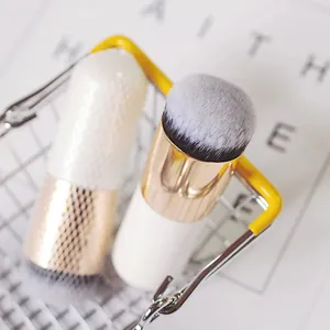 Close-up of portable chubby foundation brushes with gold ferrule and soft bristles