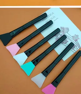 Detail view of silicone face mask brushes with black handles in various vibrant colors