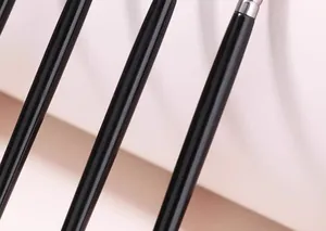 Gros plan de manches de pinceaux de maquillage noirs brillants avec des bagues métalliques.