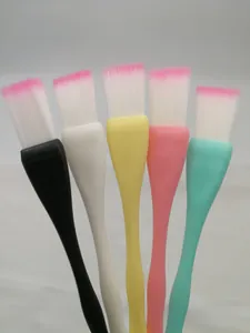 Close-up of five colorful face mask brushes with pink-tipped bristles