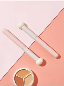 Nahaufnahme von tragbaren Schwamm-Concealer-Pinseln und dreifarbiger Concealer-Palette