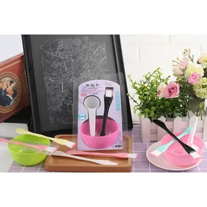 A complete DIY facial mask mixing tool set including colorful bowls and brushes in a lifestyle setting