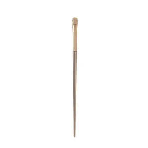 Small champagne gold crescent-shaped eyeshadow brush for precision detail makeup